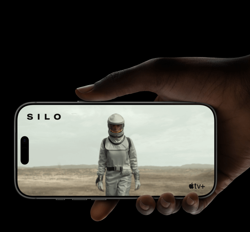 Eine Hand hält ein iPhone 17 Pro im Querformat, auf dem eine Szene aus der Serie "Silo" auf Apple TV+ abgespielt wird.